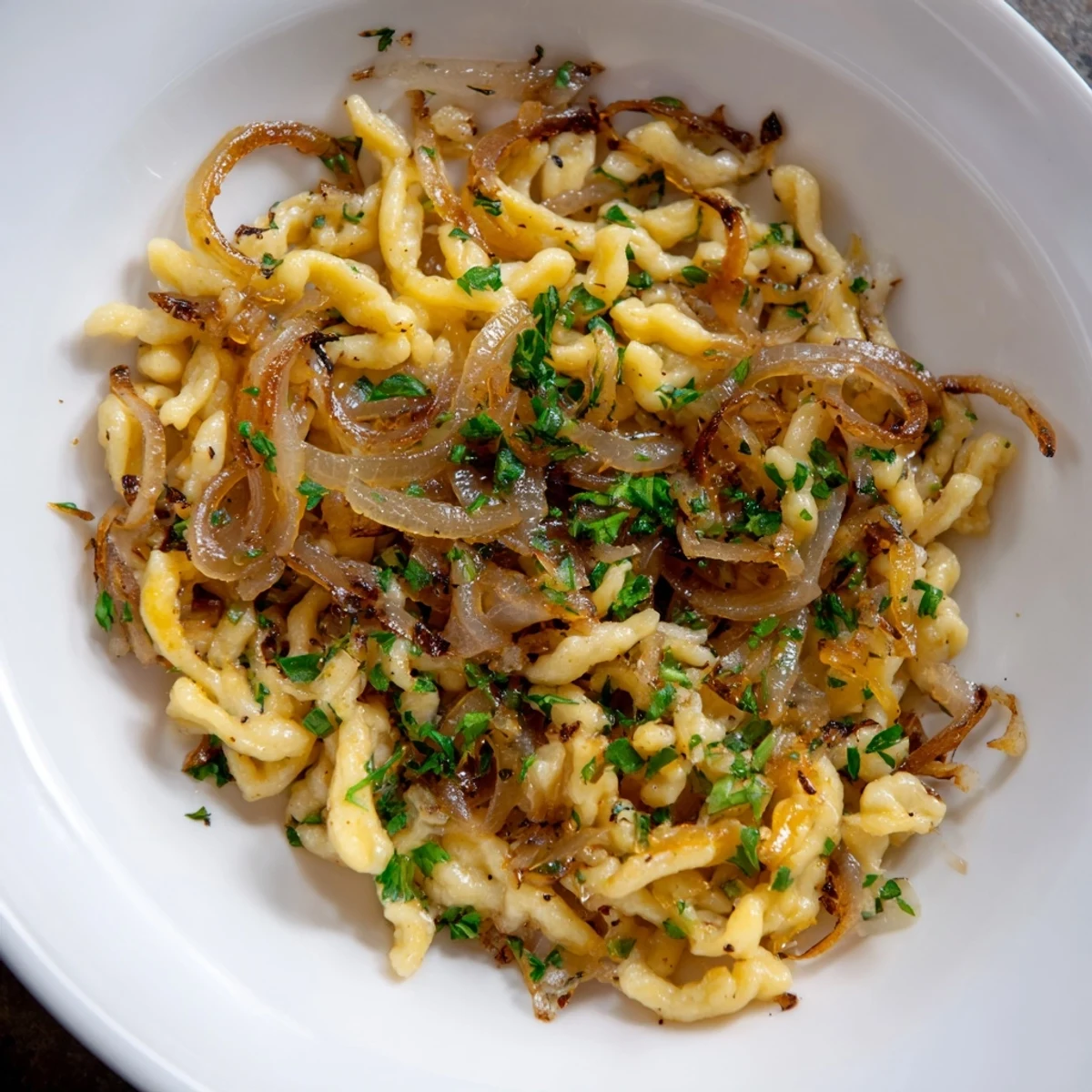 Hausgemachte Spaetzle mit süßen, goldenen Zwiebeln—eine bayerische Köstlichkeit.