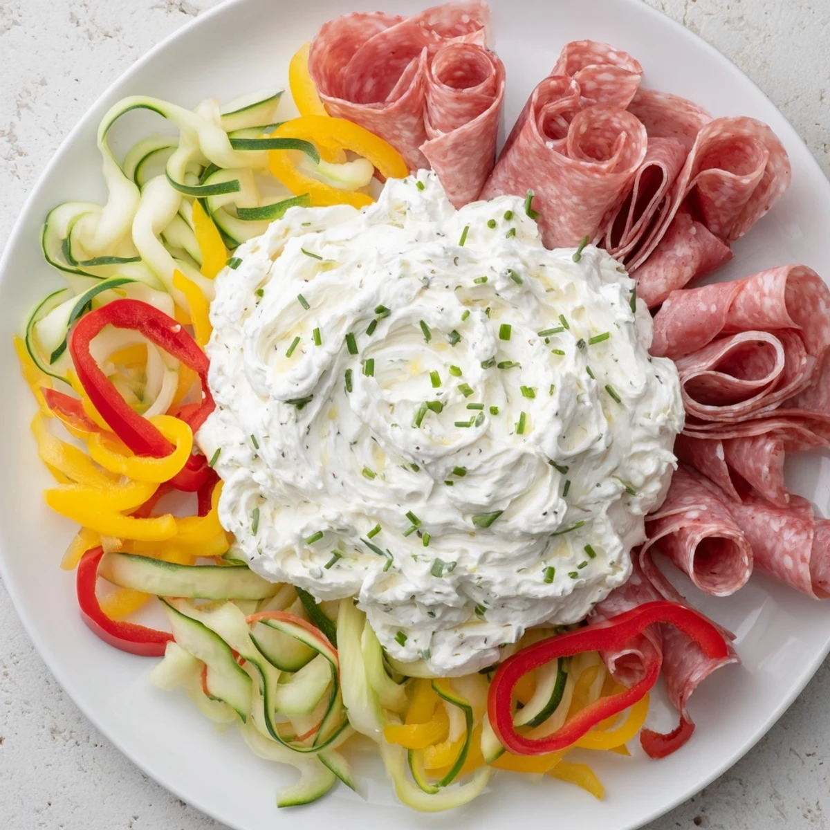 This party-ready Medusa Curls appetizer platter shows off rolled meats, vegetables, and creamy dip in the center.