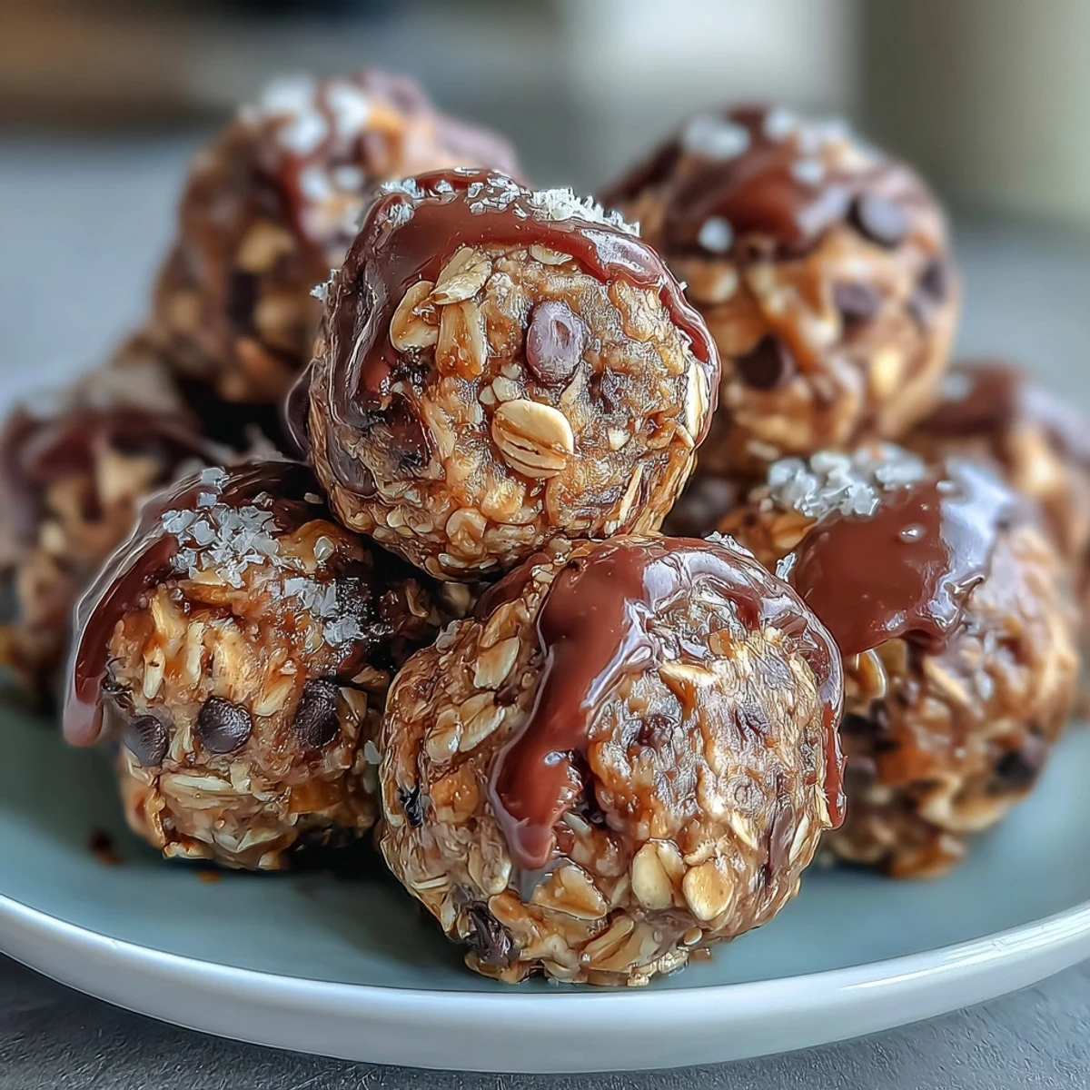 Deutliche Aufnahme von Ballformen mit Banana Chocolate Chip Energy Balls aus Hafer, Nussbutter und Schokoladenstücken auf Pergamentpapier.