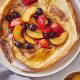 Oven-baked Quick German Pancakes feature bubbly golden edges and are piled high with fruit.