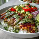 Chimichurri Chicken Bowl with juicy herb-marinated chicken and fluffy rice, garnished with lime wedges.