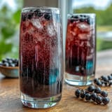 Nahaufnahme von Crème de Cassis im Weinglas, mit Champagner getoppt als klassischer Kir Royale.