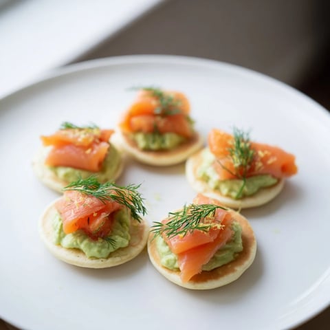 Fluffy quark blinis topped with smoked salmon, creamy avocado, ready for brunch.
