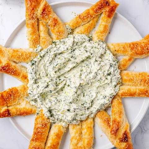 Golden, crisp edges surround a creamy pesto star-shaped dip, perfect for a party appetizer.