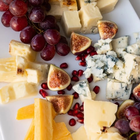 A generously overflowing The Final Curtain grazing board with fresh fruit and artisan cheeses.