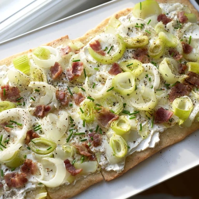 Close-up of baked Sheet-Pan Flammkuchen, showing bacon and leeks on creamy base, perfect for dinner.