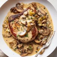 Saftige Schweinekoteletts in cremiger Pilzsauce für ein köstliches Hauptgericht.